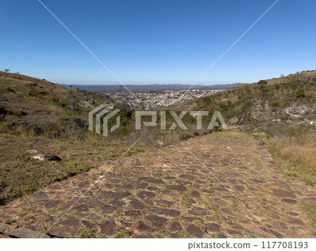 Scenic Cobblestone Path Leading to a Distant City View Scenic Cobblestone Path Leading to a Distant City View 117708193