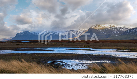 View during auto trip in West Iceland highlands, Snaefellsnes peninsula, Snaefellsjokull National Park. Spectacular volcanic tundra landscape with mountains, craters, lakes, gravel roads. 117708375