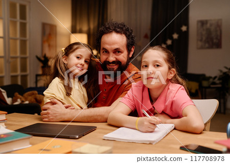 Smiling Father and Daughters Doing Homework Together Smiling Father and Daughters Doing Homework Together 117708978