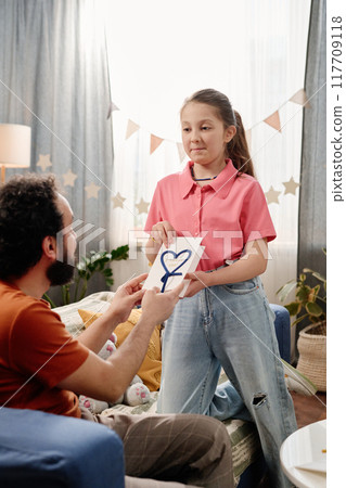 Celebrating Father's Day, Daughter Giving Heart Drawing to Father 117709118
