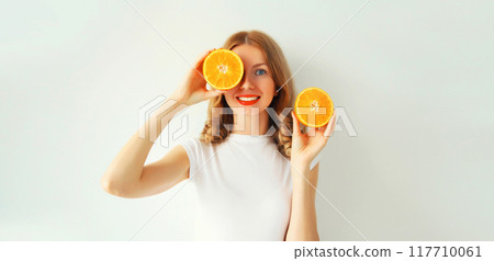 Summer, nutrition, diet concept. Happy healthy smiling young woman with slices of orange fruits Summer, nutrition, diet concept. Happy healthy smiling young woman with slices of orange fruits 117710061