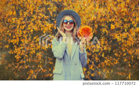 Autumn portrait of beautiful happy smiling woman with yellow maple leaves in the park Autumn portrait of beautiful happy smiling woman with yellow maple leaves in the park 117710072