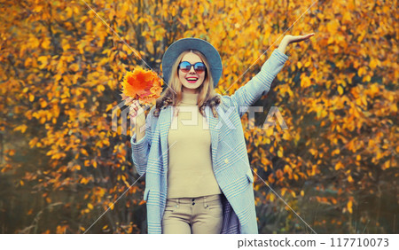 Autumn portrait of beautiful happy smiling woman with yellow maple leaves in the park Autumn portrait of beautiful happy smiling woman with yellow maple leaves in the park 117710073
