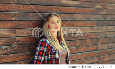 Portrait of beautiful caucasian blonde young woman in casual checkered shirt in the city Portrait of beautiful caucasian blonde young woman in casual checkered shirt in the city 117710096