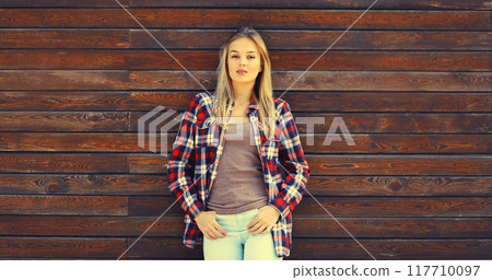 Portrait of beautiful caucasian blonde young woman in casual checkered shirt in the city Portrait of beautiful caucasian blonde young woman in casual checkered shirt in the city 117710097