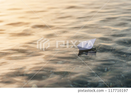 Origami white paper boat on blue deep water. Origami white paper boat on blue deep water. 117710197