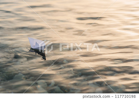 Origami white paper boat on blue deep water. 117710198