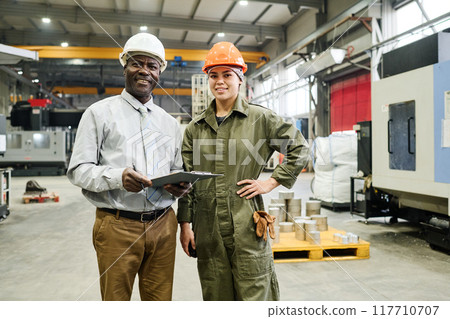 Portrait of Engineers Wearing Helmets in Industrial Facility 117710707