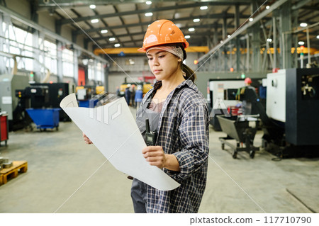 Inspecting Blueprint in Modern Manufacturing Facility Inspecting Blueprint in Modern Manufacturing Facility 117710790