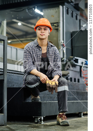 Young Worker Wearing Protective Gear in Industrial Setting 117710803