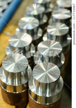 Shining Metallic Mechanical Parts on Factory Workbench 117710867