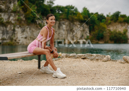 A dedicated Fitness Enthusiast Enjoying Some Relaxing Moments by the Beautiful Water Body A dedicated Fitness Enthusiast Enjoying Some Relaxing Moments by the Beautiful Water Body 117710940