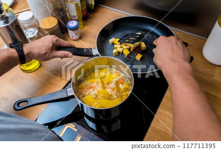 Chef at the kitchen preparing pumpkin porridge with tofu and vegetables Chef at the kitchen preparing pumpkin porridge with tofu and vegetables 117711395