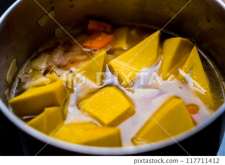 Chef at the kitchen preparing pumpkin porridge with tofu and vegetables 117711412
