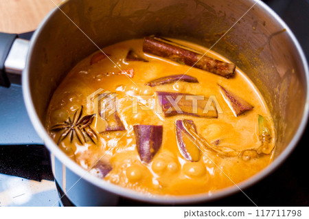 Chef at the kitchen preparing massaman curry with sweet potato and many spices Chef at the kitchen preparing massaman curry with sweet potato and many spices 117711798