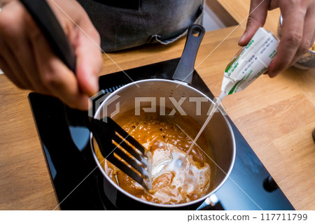 Chef at the kitchen preparing massaman curry with sweet potato and many spices Chef at the kitchen preparing massaman curry with sweet potato and many spices 117711799
