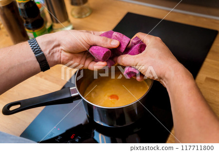 Chef at the kitchen preparing massaman curry with sweet potato and many spices 117711800