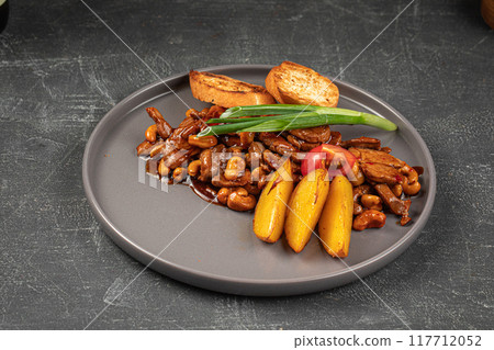 Portion of sweet and sour pork meat with potato 117712052