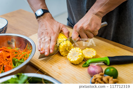Chef at the kitchen preparing spicy glass noodle salad 117712319