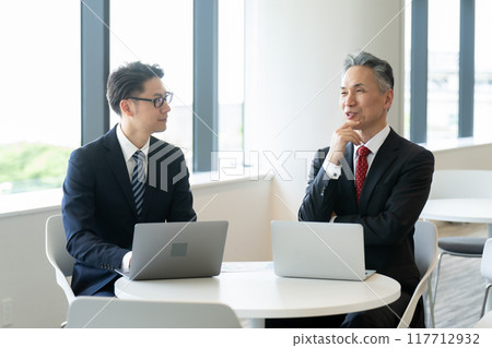 Businessmen having a meeting in the lounge 117712932
