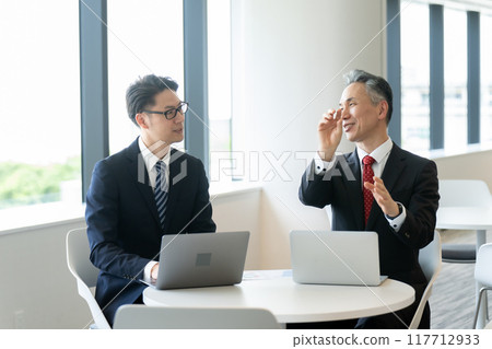 Businessmen having a meeting in the lounge 117712933
