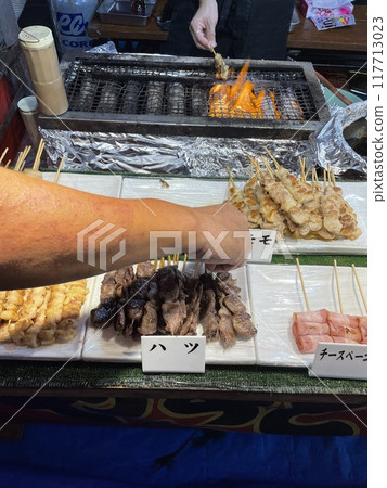 Pick up a yakitori from a food stall 117713023