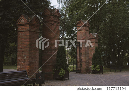 Brick columns are the entrance to the park. Gates in the forest park 117713194