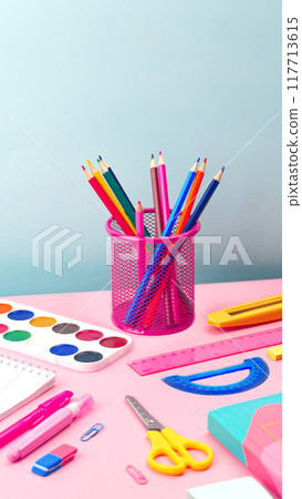 Stationery and school supplies on the table, colorful pencils in a stand. Back to school vertical banner copy space 117713615