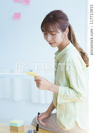 A young woman visualizing issues in the office A young woman visualizing issues in the office 117713655