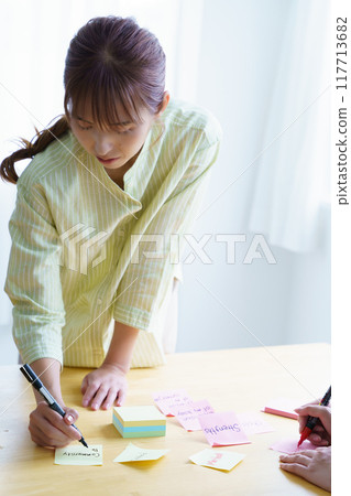 A woman who makes issues visible through teamwork A woman who makes issues visible through teamwork 117713682