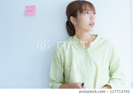 A young woman visualizing issues in the office A young woman visualizing issues in the office 117713742
