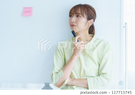 A young woman visualizing issues in the office A young woman visualizing issues in the office 117713745