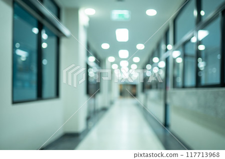 A hallway with a few lights on and a door in the background A hallway with a few lights on and a door in the background 117713968