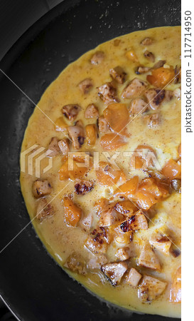 Fried eggs with mushrooms and yellow tomatoes in a frying pan. Home cooking. Fried eggs with mushrooms and yellow tomatoes in a frying pan. Home cooking. 117714950