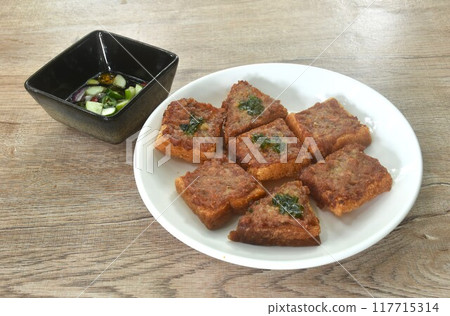 Thai crispy fried pork toast on plate eat couple with pickled vegetable sauce 117715314