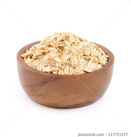 Oatmeal in wooden bowl close up on white background. Oatmeal in wooden bowl close up on white background. 117715377