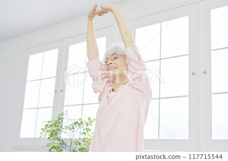 Senior woman stretching in the living room Senior woman stretching in the living room 117715544