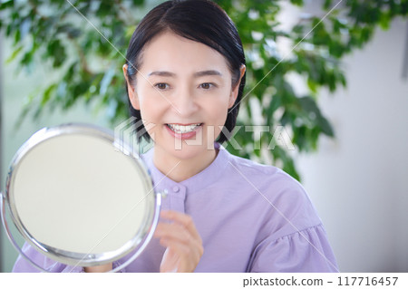 中年婦女在客廳做皮膚護理 117716457
