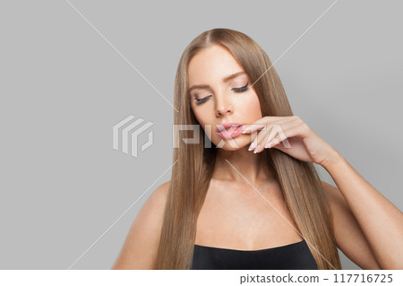 Lovely female model brunette with long hair and natural make-up posing isolated on white background Lovely female model brunette with long hair and natural make-up posing isolated on white background 117716725