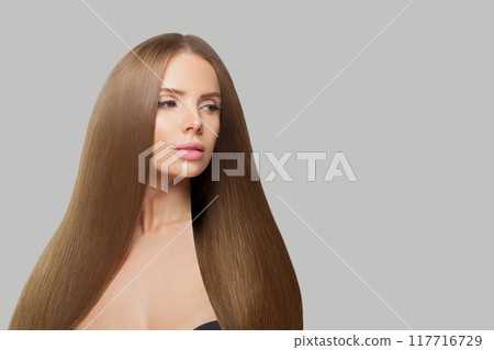 Glorious woman face. Model with long brown hair and make-up on grey background.  117716729