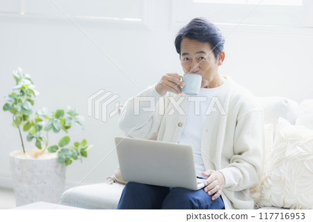 中年男子在客廳使用筆記型電腦 中年男子在客廳使用筆記型電腦 117716953