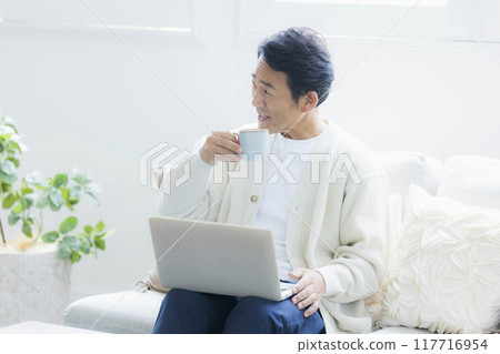 中年男子在客廳使用筆記型電腦 117716954