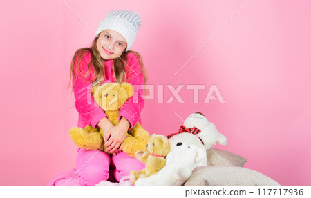 Unique attachments to stuffed animals. Kid little girl play with soft toy teddy bear pink background. Child small girl playful hold teddy bear plush toy. Teddy bears improve psychological wellbeing 117717936