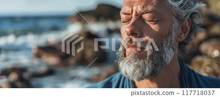 Mature man with closed eyes and gray beard at the beach 117718037