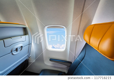 Beautiful view from airplane window seat above clouds during flight. Concept of sky and travel Beautiful view from airplane window seat above clouds during flight. Concept of sky and travel 117718215