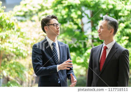Businessmen having business meetings outdoors, fresh greenery 117718511