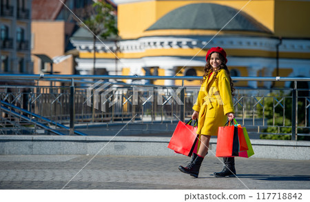shopaholic teenage girl go shopping in autumn coat during sale and discount holding purchase shopper bag outdoor, copy space shopaholic teenage girl go shopping in autumn coat during sale and discount holding purchase shopper bag outdoor, copy space 117718842