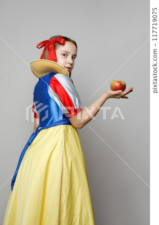 Pretty young girl theater actress in SnowWhite costume holding apple and standing  Pretty young girl theater actress in SnowWhite costume holding apple and standing  117719075