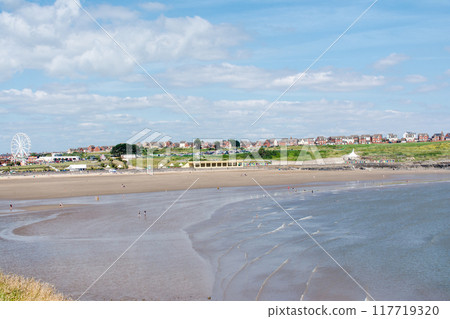 人們在南威爾斯郊區的淺沙灘上放鬆,遠處山上有一排紅磚房 人們在南威爾斯郊區的淺沙灘上放鬆,遠處山上有一排紅磚房 117719320