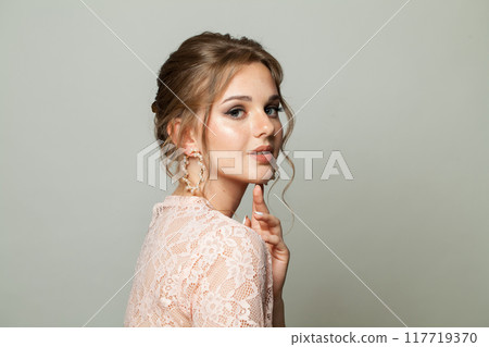 Pretty elegance woman with fresh skin, updo hair and makeup on white background. Pretty elegance woman with fresh skin, updo hair and makeup on white background. 117719370